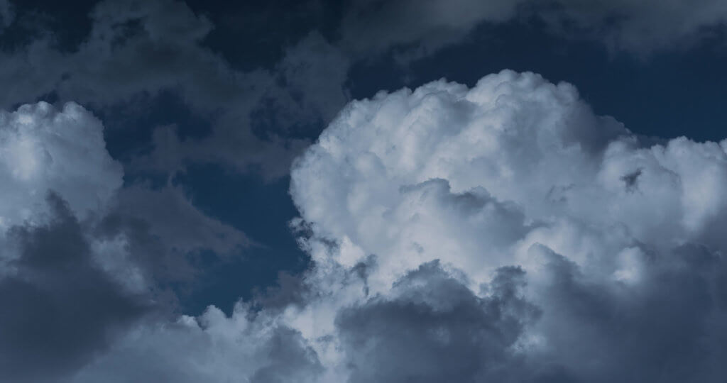 An image of clouds in a dark blue sky