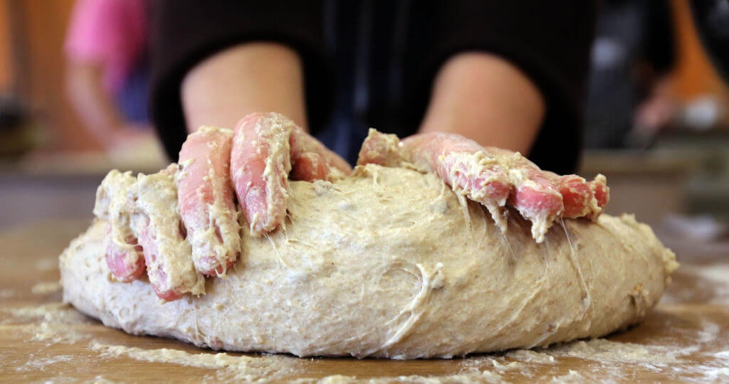 Image of hands covered in dough making bread