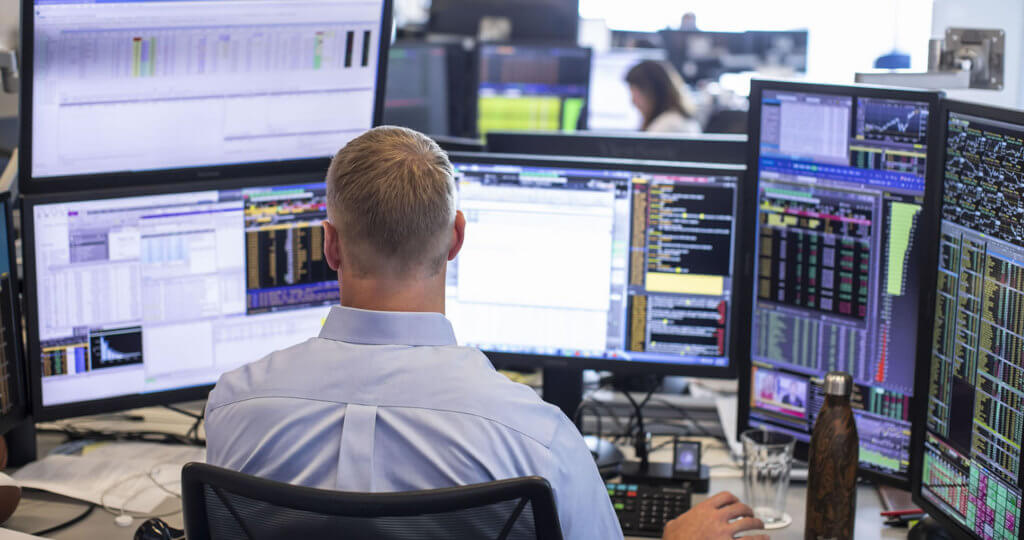 Trading desk with man working at his computer