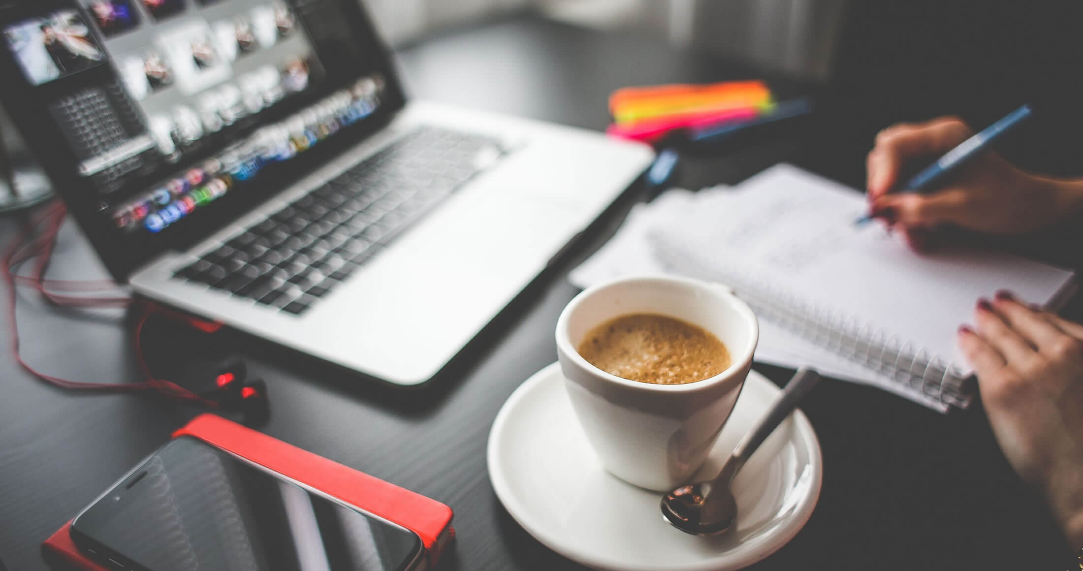 Woman working at a table with a laptop and coffee